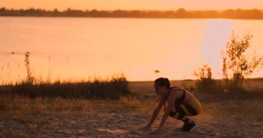 Fitness kadın lunge streç egzersiz yapıyor germe. Kadın atlet eğitim lunges plaj gün batımı sırasında Siluet güzel doğada dışında uzanır.