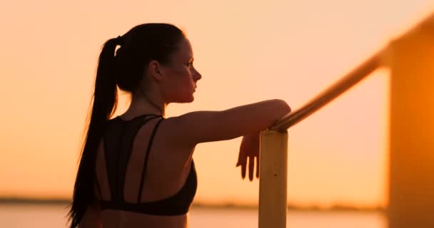 O tema mulheres esportes e saúde. Mulher caucasiana bonita com cabelos longos encaracolados posando em esportes ao ar livre terra segurando hor. O tema mulher esportes e saúde . — Vídeo de Stock