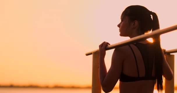 Het thema vrouwen sport en gezondheid. Mooie blanke vrouw met krullend lang haar poseren op outdoor sport grond Holding Hor. De thema vrouw sport en gezondheid. — Stockvideo