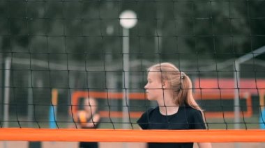 Profesyonel voleybol plaj turnuvasında kadın hizmet vermektedir. Voleybol net oyuncu uygularken görünümü engeller