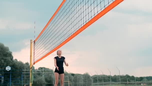 Mujeres compitiendo en un torneo profesional de voleibol playa. Una defensora intenta detener un disparo durante el voleibol playa profesional internacional de 2 mujeres — Vídeo de stock