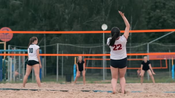 Профессиональный волейбол обслуживает женщин на пляжном турнире. Волейбольная сетка игрок блокирует вид при применении — стоковое видео