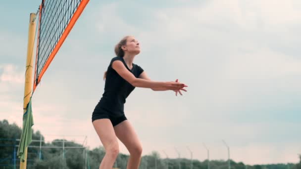 Mulheres competindo em um torneio profissional de vôlei de praia. Um defensor tenta parar um tiro durante o vôlei de praia profissional internacional de 2 mulheres — Vídeo de Stock