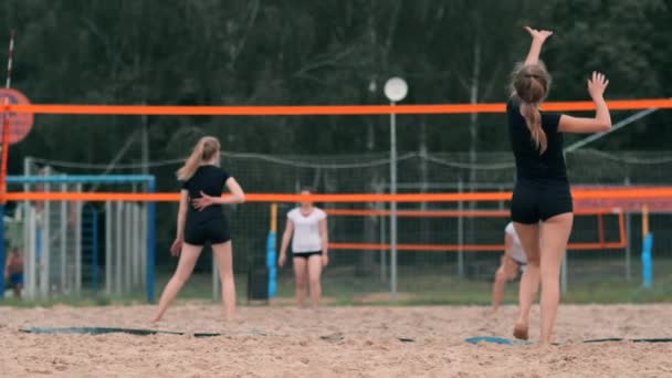 Profesyonel voleybol plaj turnuvasında kadın hizmet vermektedir. Voleybol net oyuncu uygularken görünümü engeller — Stok video