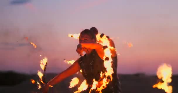 Danseurs du feu contre le coucher du soleil. Une jeune femme pose avec son cerceau de feu contre le coucher du soleil lors de son spectacle de danse . — Video