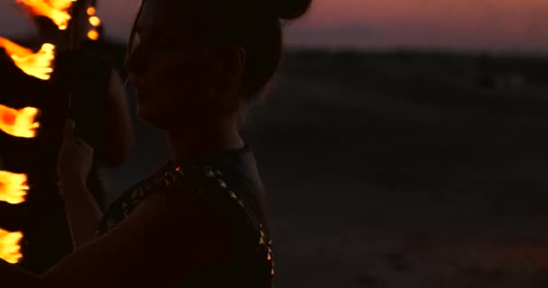 Bir grup erkek ve kadın kumda gece ateş gösterisi — Stok video