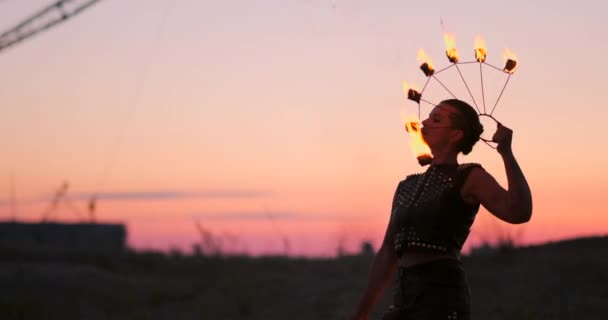 Bailarinas de fuego contra el atardecer. Una joven posa con su aro de fuego contra el atardecer durante su actuación de baile . — Vídeos de Stock