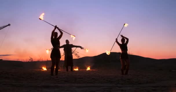 Espectáculo. Um grupo de artistas profissionais realiza uma variedade de instalações de incêndio. Meninos e meninas realizaram danças com fogo na noite na rua no Parque . — Vídeo de Stock