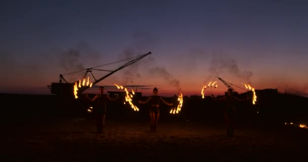 Fire show. Grupa profesjonalnych artystów wykonuje różnorodne udogodnienia, ogień. Chłopcy i dziewczęta wykonywane tańce z ogniem w nocy na ulicy, w parku. — Wideo stockowe