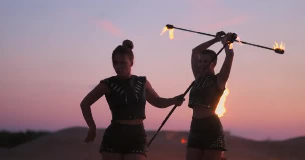 Dançarinos de fogo contra o pôr-do-sol. Uma jovem posa com seu arco de fogo contra o pôr do sol durante sua performance de dança . — Vídeo de Stock