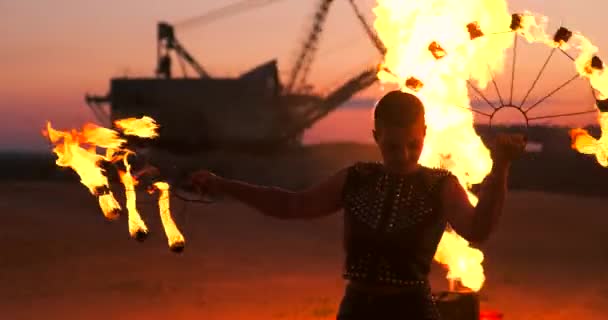 Danseurs du feu contre le coucher du soleil. Une jeune femme pose avec son cerceau de feu contre le coucher du soleil lors de son spectacle de danse . — Video