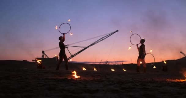 Fire show. Grupa profesjonalnych artystów wykonuje różnorodne udogodnienia, ogień. Chłopcy i dziewczęta wykonywane tańce z ogniem w nocy na ulicy, w parku. — Wideo stockowe