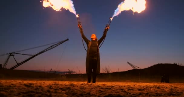 Ein Mann mit einem Flammenwerfer bei Sonnenuntergang in Zeitlupe. Kostüm für Zombie-Apokalypse und Halloween. — Stockvideo