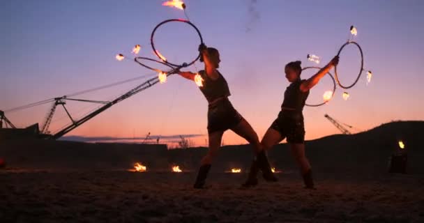Artistas profissionais mostram um show de fogo em um festival de verão na areia em câmera lenta. acrobatas quarta pessoa de trabalho de circo com fogo à noite na praia . — Vídeo de Stock