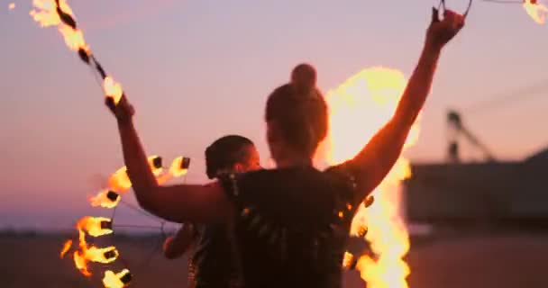Professionella dansare kvinnor gör en eldshow och pyrotekniska prestanda på festivalen med brinnande gnistrande facklor. — Stockvideo