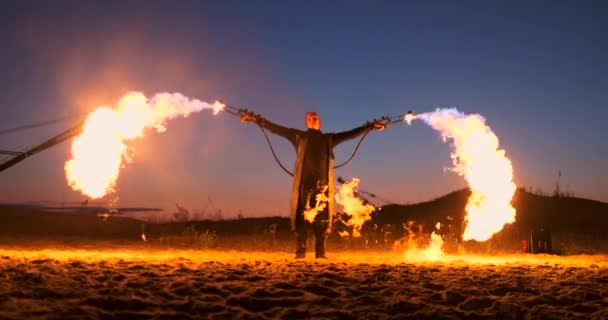 Een man met een vlammenwerper bij zonsondergang in slow motion. Kostuum voor zombie apocalyps en Halloween. — Stockvideo