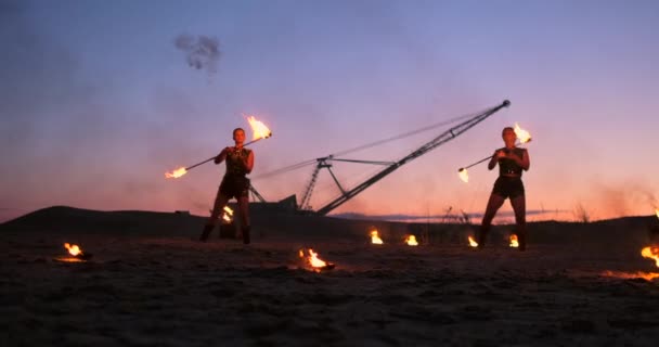 火災ショー。プロのアーティストのグループは、様々 な消防設備を実行します。男の子と女の子が公園の通りに夜の火踊りを実行. — ストック動画
