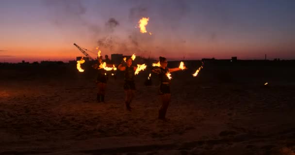 Fire show. Grupa profesjonalnych artystów wykonuje różnorodne udogodnienia, ogień. Chłopcy i dziewczęta wykonywane tańce z ogniem w nocy na ulicy, w parku. — Wideo stockowe