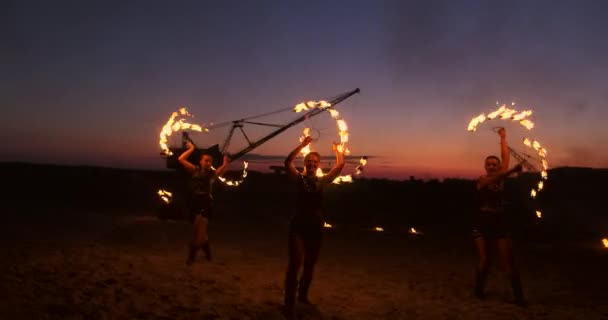 Fire show. Grupa profesjonalnych artystów wykonuje różnorodne udogodnienia, ogień. Chłopcy i dziewczęta wykonywane tańce z ogniem w nocy na ulicy, w parku. — Wideo stockowe