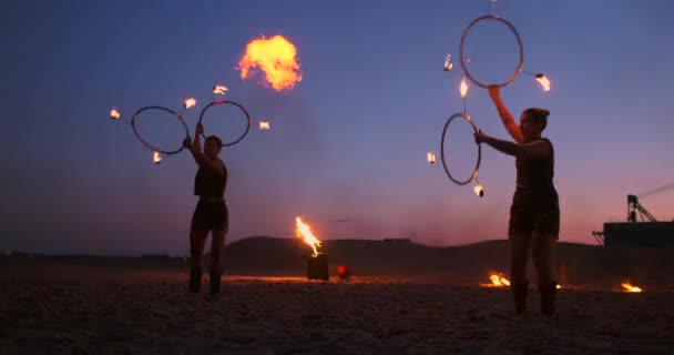 Παράσταση με φωτιές. Μια ομάδα από επαγγελματίες καλλιτέχνες εκτελεί μια ποικιλία από εγκαταστάσεις πυρκαγιάς. Αγόρια και κορίτσια εκτελούνται χοροί με φωτιά το βράδυ την street στο πάρκο. — Αρχείο Βίντεο