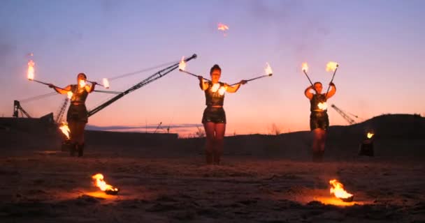 Espectáculo. Um grupo de artistas profissionais realiza uma variedade de instalações de incêndio. Meninos e meninas realizaram danças com fogo na noite na rua no Parque . — Vídeo de Stock