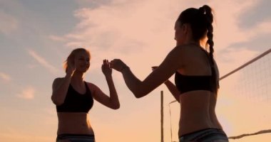 Voleybol maçından sonra iki genç kız yüksek beşlik veriyor,