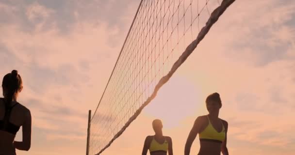 Grupp unga flickor spela beachvolley under solnedgång eller soluppgång, Slow Motion, — Stockvideo