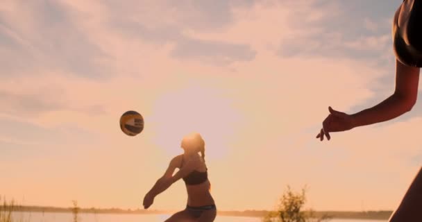 Sexy niñas jugadores de voleibol pasan la pelota cerca de la red y golpear la pelota al atardecer en cámara lenta — Vídeos de Stock