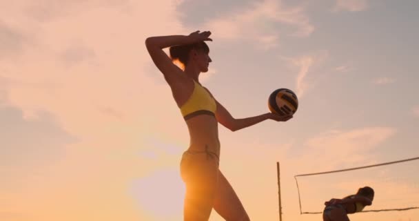 Пляжный волейбол служат - женщина, выступающая в игре пляжный волейбол. Наружный пик подается. Молодые люди, веселящиеся на солнце, живут здоровым активным спортивным образом жизни на открытом воздухе . — стоковое видео