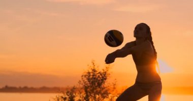 Gün batımında plajda bikini resepsiyon voleybol güzel kadın hizmet