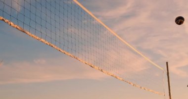 Grup Genç kızların plaj voleybolu günbatımı ve gündoğumu, ağır çekim sırasında çalıştırmak,