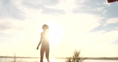 Yavaş Hareket, Düşük Açı, Close Up, Sun Flare: Plaj voleybolu oynayan atletik kız havada atlar ve güzel bir yaz akşamı net üzerinden topa vurur. Beyaz kadın bir puan