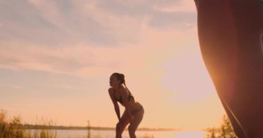 Grup Genç kızların plaj voleybolu günbatımı ve gündoğumu, ağır çekim sırasında çalıştırmak,