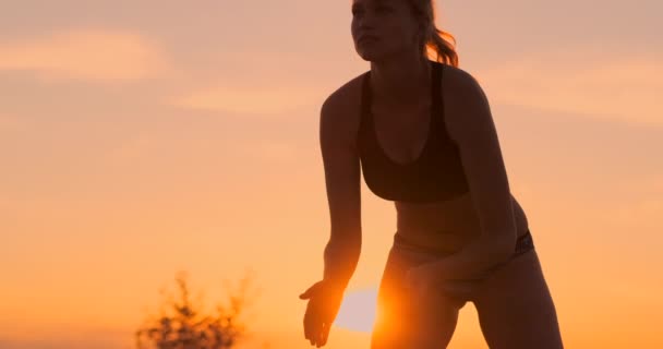 Servir recepción voleibol hermosa mujer en bikini en la playa al atardecer — Vídeo de stock