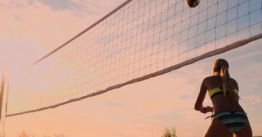 Grup genç kızların plaj voleybolu günbatımı ve gündoğumu sırasında çalıştırmak.