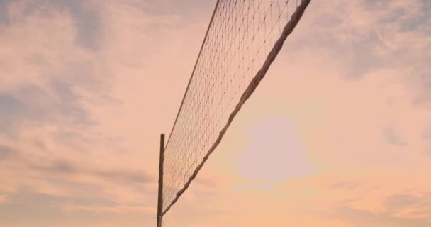 Beachvolleyball-Mädchen schlagen den Ball bei Sonnenuntergang im Sand in Zeitlupe. — Stockvideo