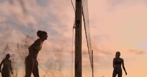 ビーチで美しいビキニの女の子はスローモーションでバレーボールをプレイ. — ストック動画