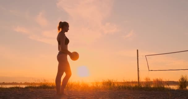 Молода дівчина стрибає служити волейболу на пляжі, повільний рух . — стокове відео