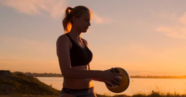 Chica atlética jugando voleibol playa salta en el aire y golpea la pelota sobre la red en una hermosa noche de verano. Mujer caucásica puntuación de un punto — Vídeos de Stock