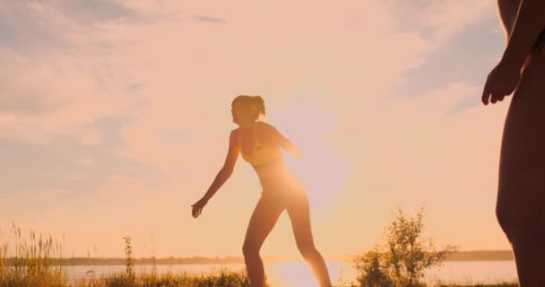 Beach volley match girls ha colpito la palla al rallentatore al tramonto sulla sabbia . — Video Stock