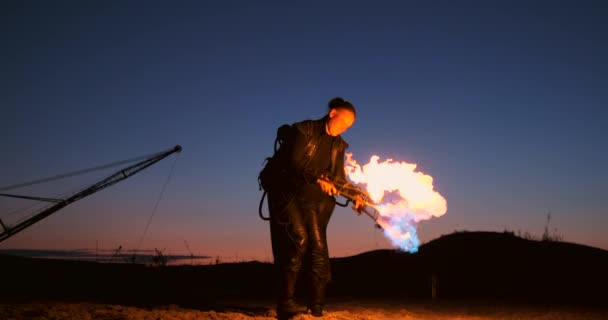 Человек с огнемётом на закате в замедленной съемке. Костюм для зомби-апокалипсиса и Хэллоуина . — стоковое видео