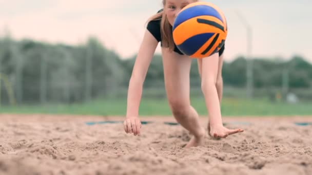 Movimiento lento: una mujer joven saltando en la caída golpea la pelota en la arena. Jugador de voleibol hace un equipo y juega la pelota en el otoño — Vídeo de stock