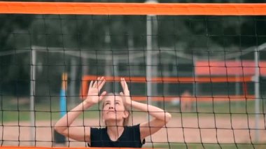 Dört kız voleybolcular kum üzerinde yavaş çekim de turnuvaya katılan yaz aylarında plajda oynamak.