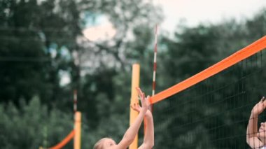 Profesyonel voleybol plaj turnuvasında kadın hizmet vermektedir. Voleybol net oyuncu uygularken görünümü engeller