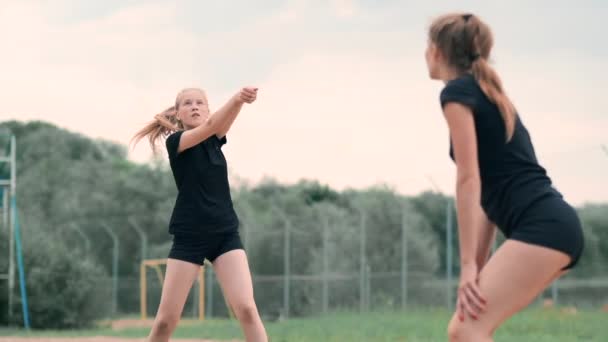 Mujeres compitiendo en un torneo profesional de voleibol playa. Una defensora intenta detener un disparo durante el voleibol playa profesional internacional de 2 mujeres — Vídeos de Stock