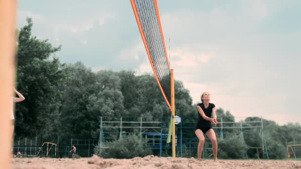 Жінки змагаються в професійному турнірі з пляжного волейболу. Захисник спроби зупинити постріл під час 2 жінок міжнародного професійного пляжного волейболу — стокове відео