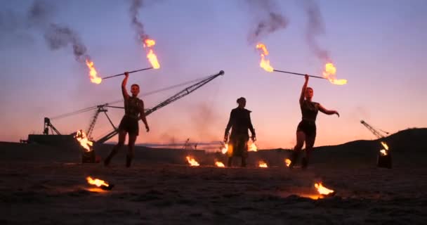 Fire show. Grupa profesjonalnych artystów wykonuje różnorodne udogodnienia, ogień. Chłopcy i dziewczęta wykonywane tańce z ogniem w nocy na ulicy, w parku. — Wideo stockowe