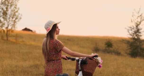 Tyttö pyörällä varustetussa hatussa kääntyy ympäri ja katsoo kameraa hymyillen. . — kuvapankkivideo