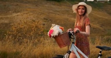 Elbise orta plan kız alanında bisiklet ve çiçekler ile gider.