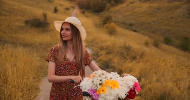 Közép-terv lány ruha megy a kerékpáros és a virágok a területen. — Stock videók